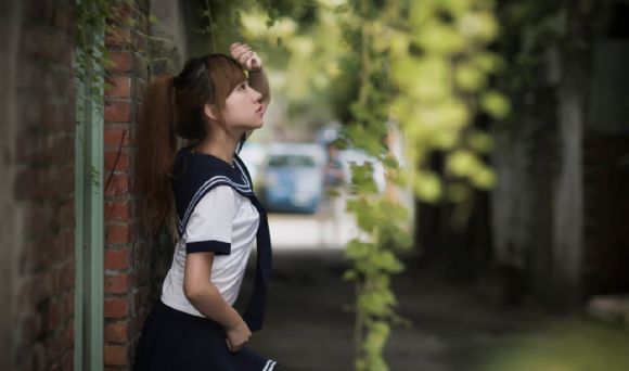 学生制服装美女靠墙PPT背景图片